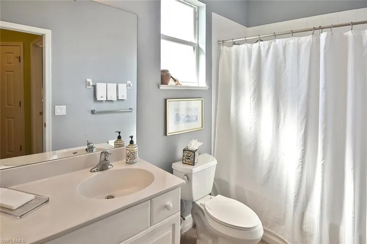 Bathroom featuring toilet, vanity, and tiled tub/shower combination