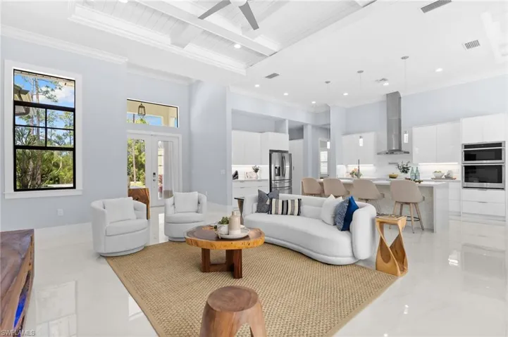 Tile flooring throughout and soaring 12’–14’ ceilings accented with wood paneling and coffered detailing.