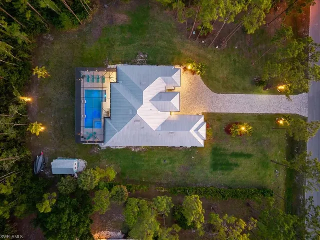 Positioned well off the road, this property is enhanced by a new 240-foot paver driveway (2024), elegant exterior and landscape lighting, and a separate storage shed.