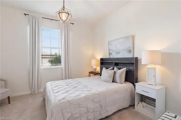 Bedroom featuring light colored carpet and baseboards