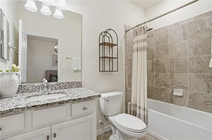 Ensuite bathroom featuring vanity and shower / bath combination with curtain