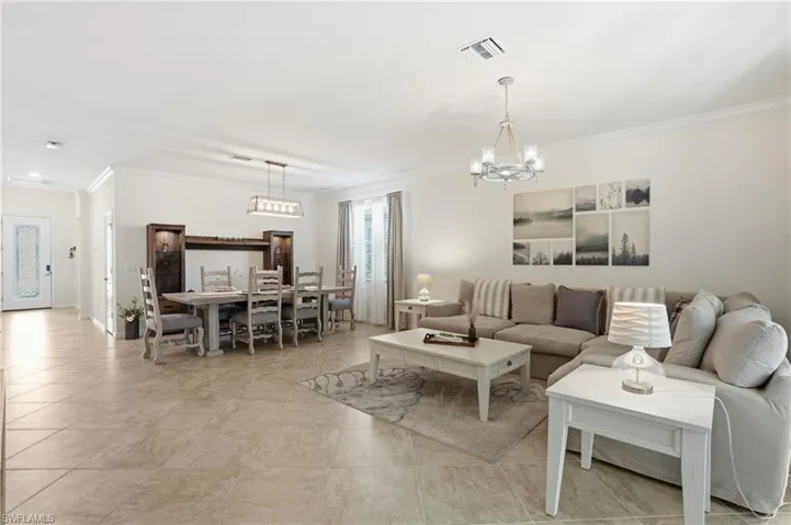 Living area featuring ornamental molding and a chandelier