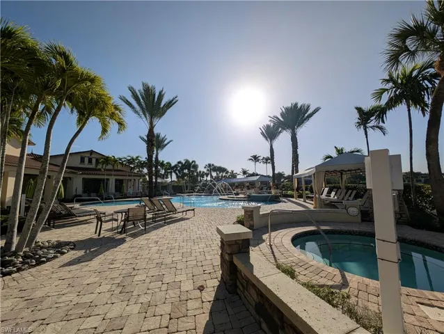 Community pool with a patio area and a community hot tub