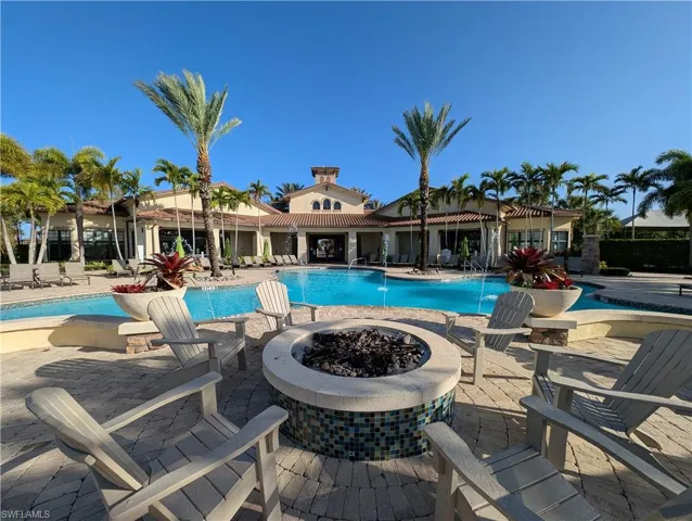 Community pool with a patio area and an outdoor fire pit