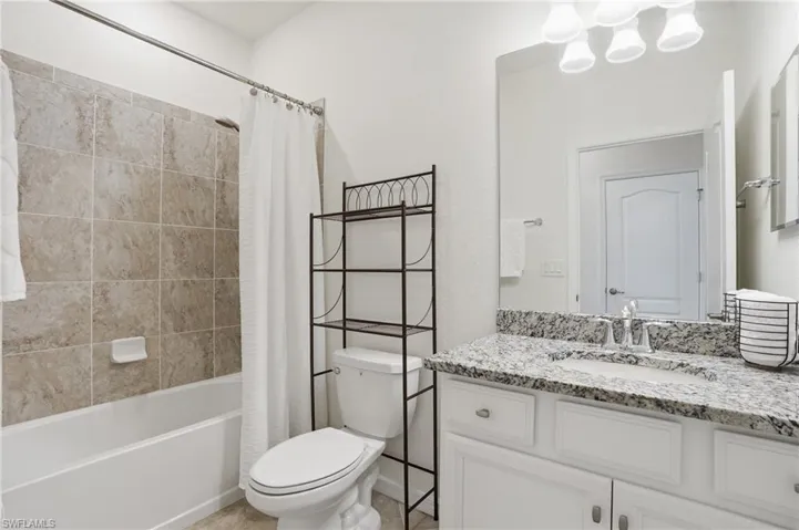 Bathroom featuring vanity and shower / bath combination with curtain