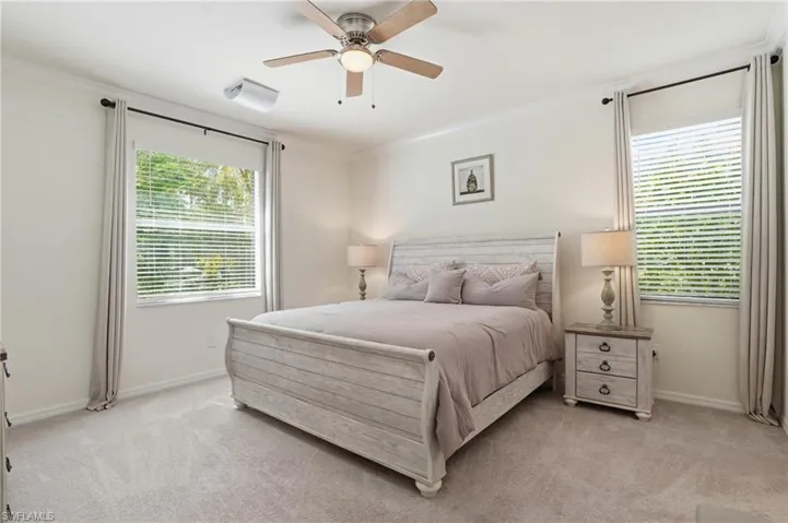 Bedroom featuring ornamental molding, light carpet, and ceiling fan