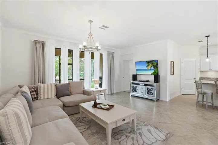 Living room with ornamental molding and a chandelier