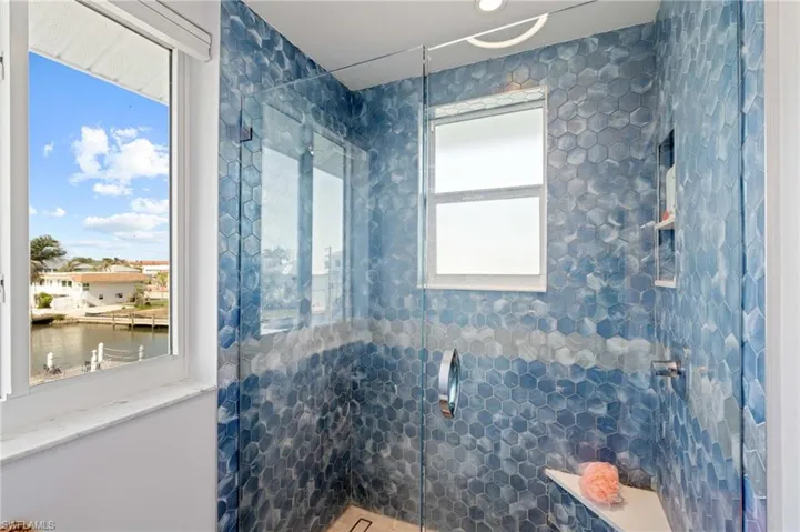 Bathroom with walk in shower and a water view /  virtually enhanced photo
