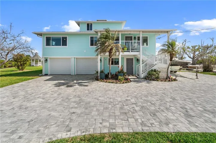 View of front of house featuring a garage and covered porch Virtually enhanced