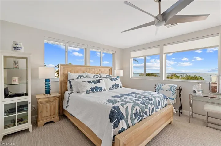 Bedroom with ceiling fan and light carpet / virtually enhanced