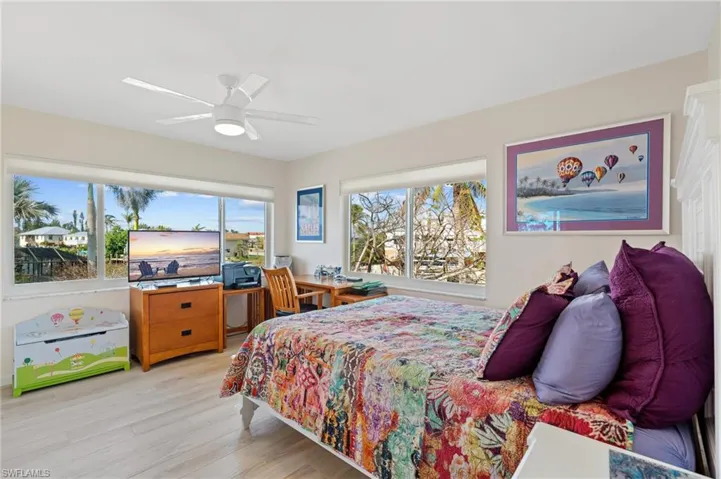 Bedroom featuring ceiling fan and light hardwood / wood-style flooring /  virtually enhanced photo