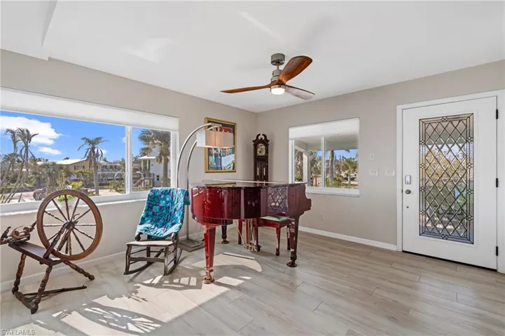 Sitting room featuring light hardwood / wood-style floors and ceiling fan / Virtually enhanced