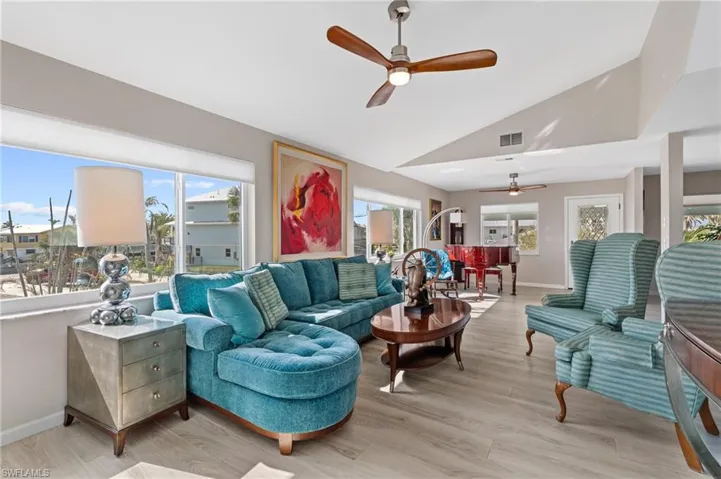 Living room featuring vaulted ceiling, plenty of natural light, ceiling fan, and light hardwood / wood-style floors / virtually enhanced