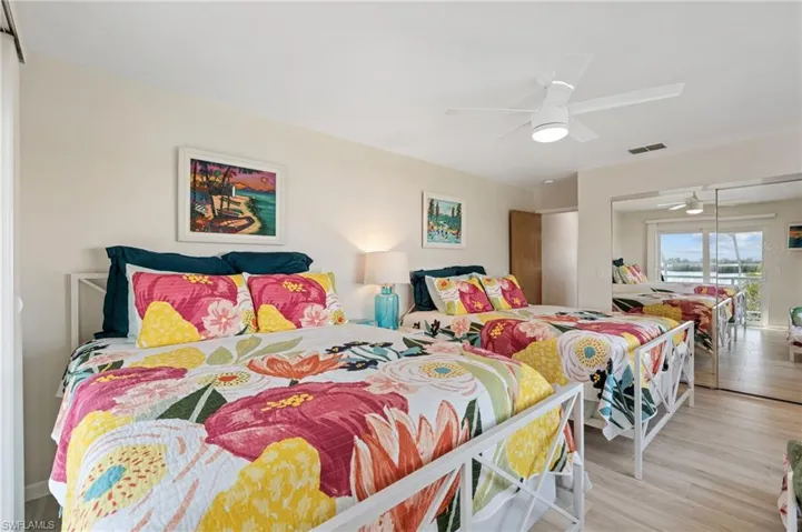 Bedroom with access to exterior, light hardwood / wood-style flooring, and ceiling fan /  virtually enhanced photo