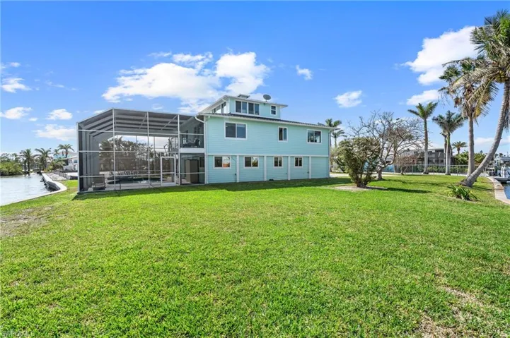 Back of property with a yard and a lanai VIRTUALLY ENHANCED