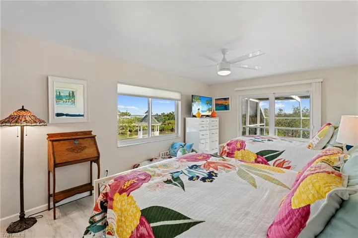 Bedroom with ceiling fan, access to outside, and light wood-type flooring /  virtually enhanced photo