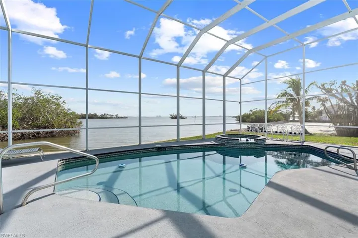 View of pool with a water view, an in ground hot tub, a lanai, and a patio / virtually enhanced