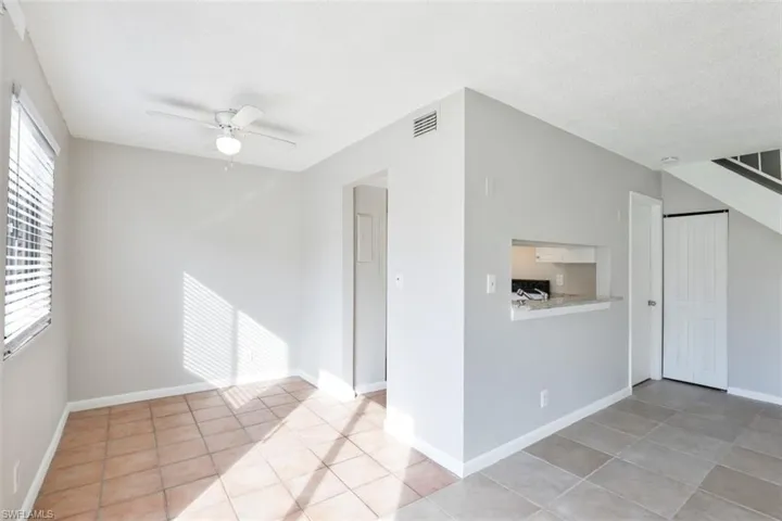 Empty room featuring a textured ceiling, ceiling fan, and light tile patterned floors