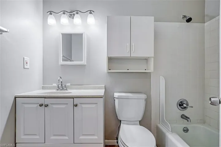 Full bathroom with toilet, vanity, and tiled shower / bath