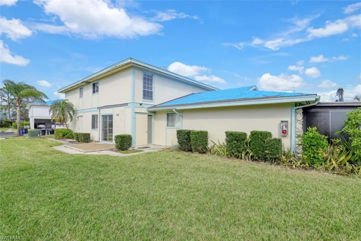 Back of property with a lawn
