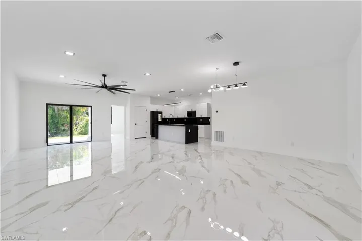 Unfurnished living room featuring a sink, visible vents, recessed lighting, and marble finish floor