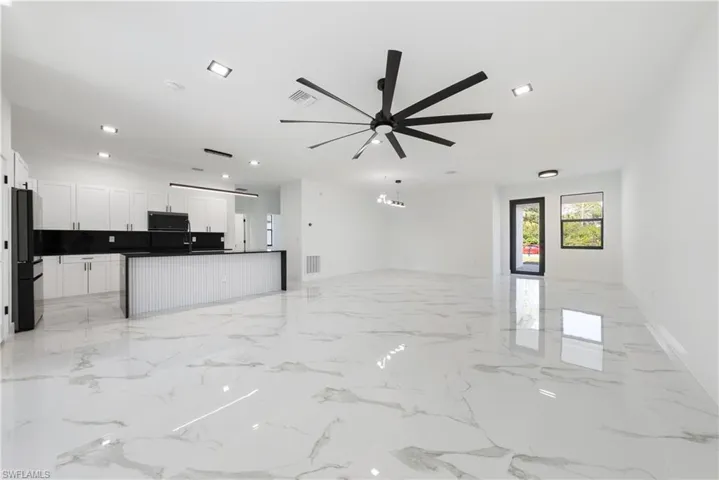 Unfurnished living room featuring recessed lighting, visible vents, marble finish floor, and ceiling fan