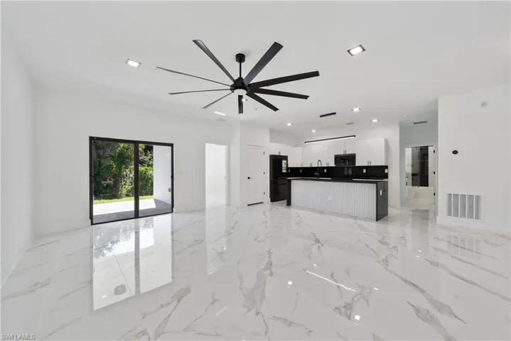 Unfurnished living room with recessed lighting, visible vents, ceiling fan, marble finish floor, and a sink
