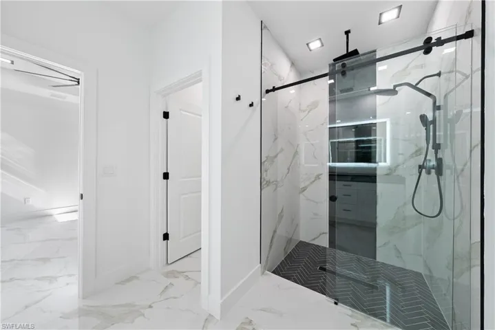Bathroom with marble finish floor, baseboards, and a marble finish shower