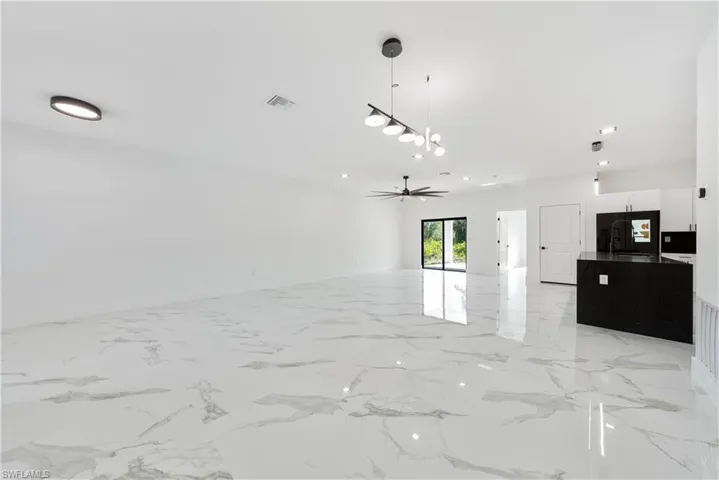 Unfurnished living room featuring marble finish floor, baseboards, visible vents, and recessed lighting
