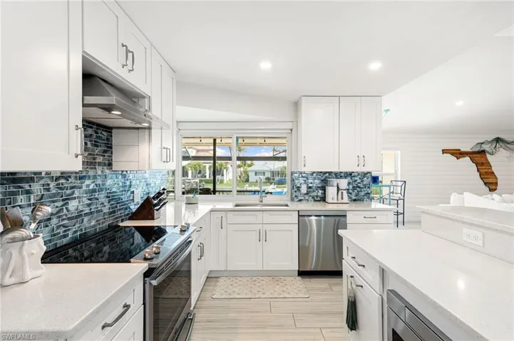 Kitchen with stainless steel appliances, white cabinets, and recessed lighting