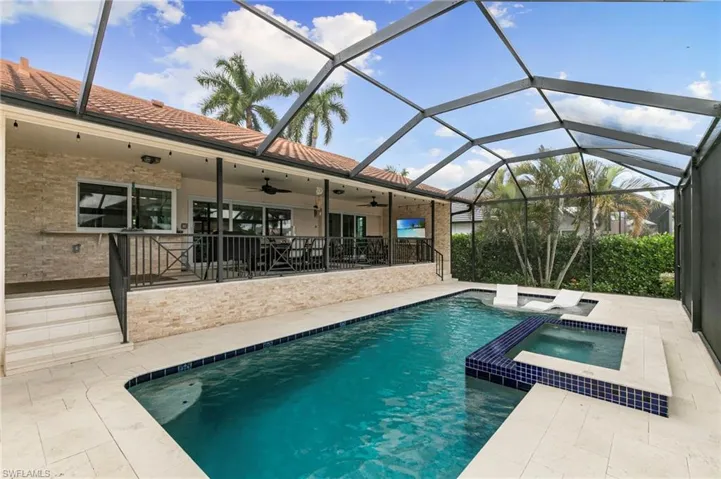 Integrated pool / hot tub with a patio, a sunroom, and a lanai
