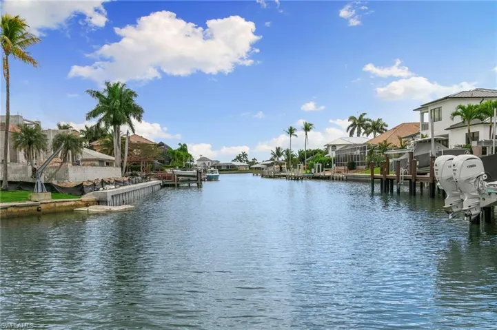 Water view featuring nearby suburban area and a dock