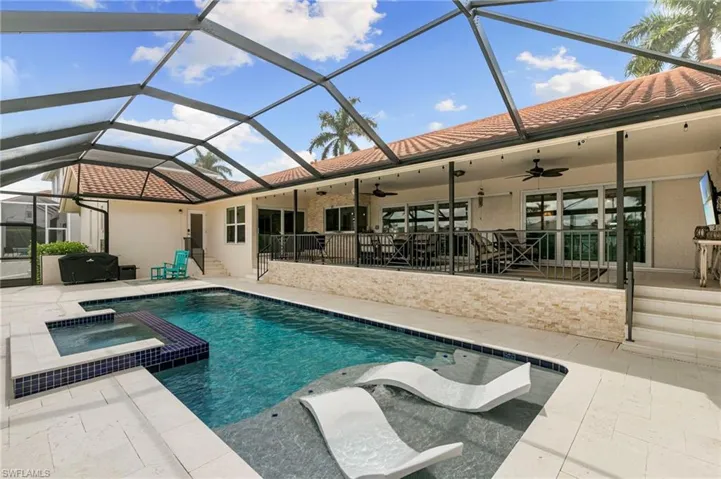 Combined pool / hot tub with a sunroom, a patio, and glass enclosure
