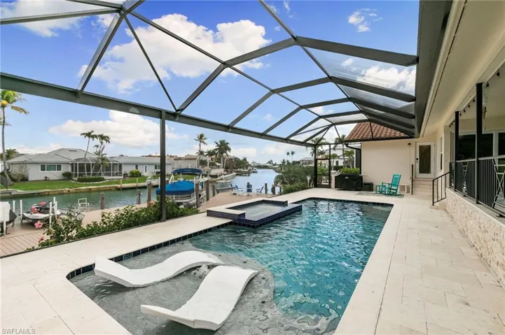 Integrated pool / spa with a sunroom, a patio area, a water view, a lanai, and boat lift