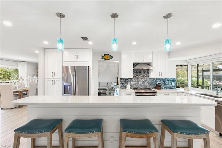 Kitchen featuring plenty of natural light, a kitchen breakfast bar, and white cabinetry