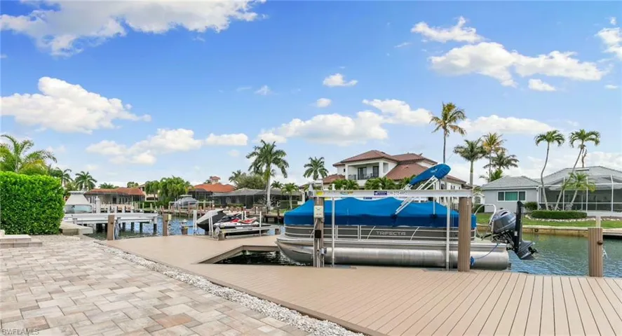Dock featuring boat lift, a water view, and a residential view