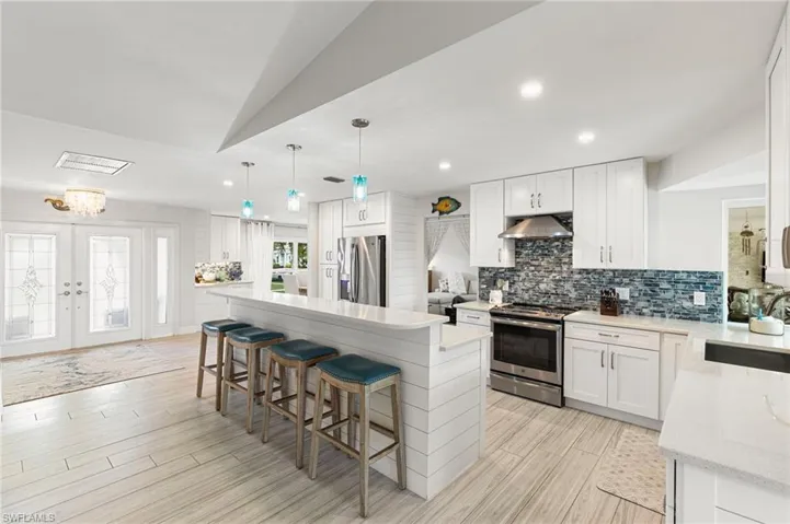 Kitchen with stainless steel appliances, a breakfast bar, and white cabinets