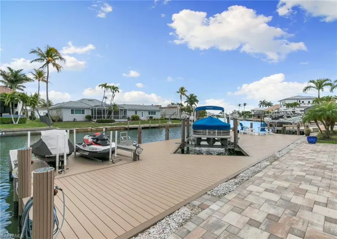 Dock area featuring boat lift, a water view, and a residential view