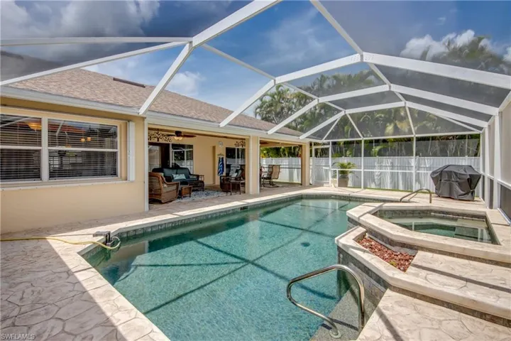 View of swimming pool with a lanai, grilling area, an in ground hot tub, a patio area, and ceiling fan