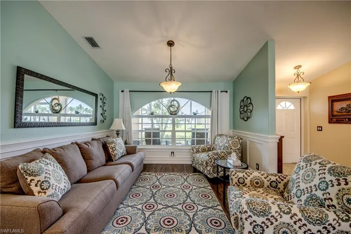 Living room featuring vaulted ceiling and wood-type flooring