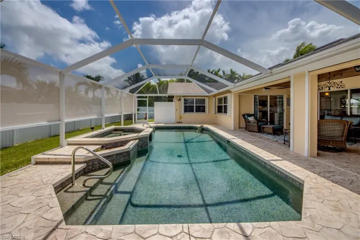 View of pool with a patio, glass enclosure, an in ground hot tub, and ceiling fan