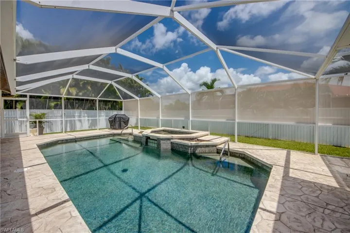 View of swimming pool with a patio area, an in ground hot tub, and a lanai