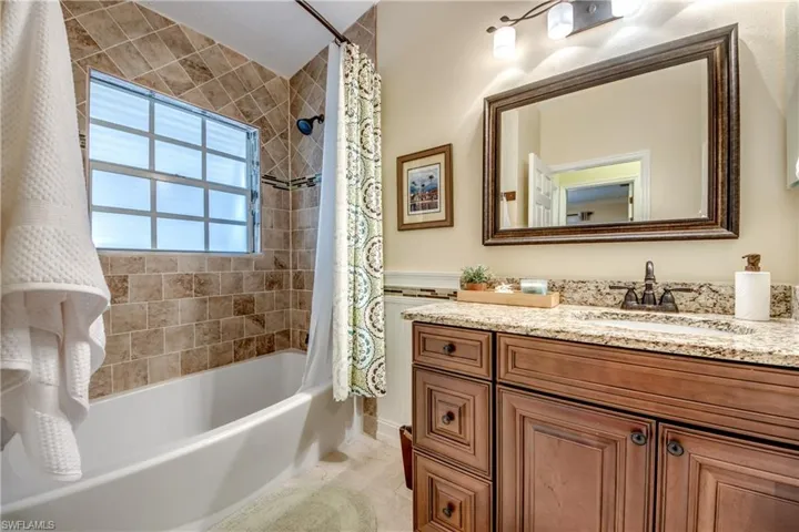 Bathroom with shower / bathtub combination with curtain and vanity