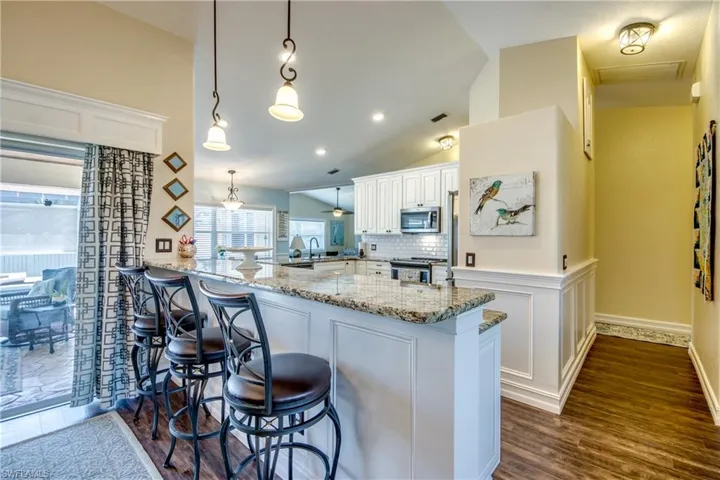Kitchen featuring appliances with stainless steel finishes, kitchen peninsula, and vaulted ceiling