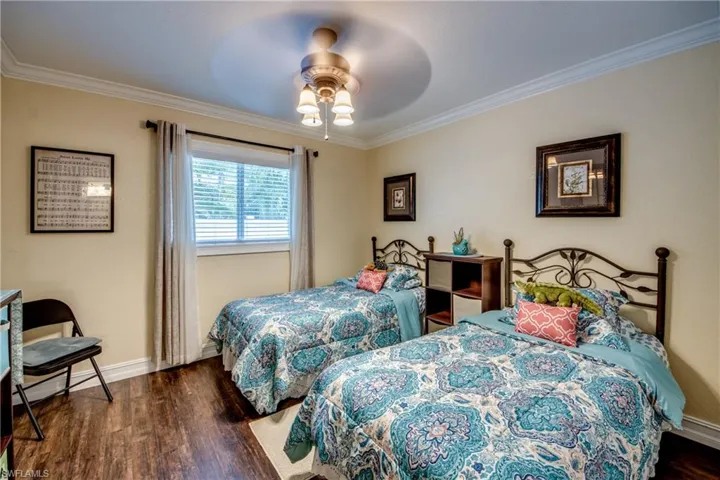 Bedroom featuring ceiling fan, dark hardwood / wood-style floors, and crown molding
