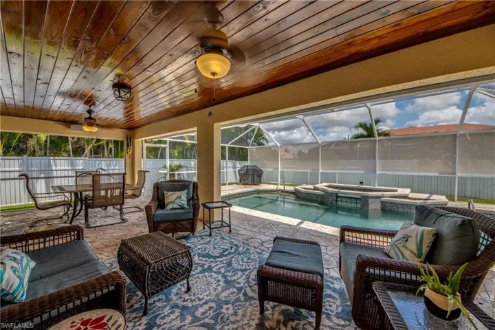 View of pool with a patio area, outdoor lounge area, an in ground hot tub, glass enclosure, and ceiling fan