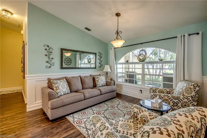 Living room with lofted ceiling and dark hardwood / wood-style flooring