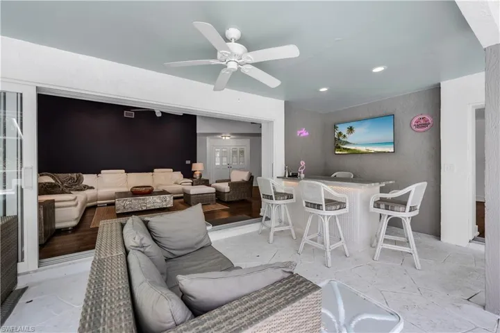 Living room featuring ceiling fan, bar, and recessed lighting
