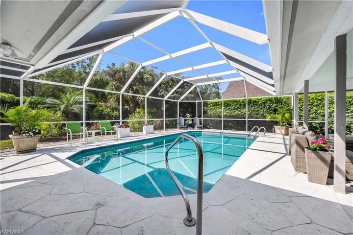 Swimming pool featuring a patio, glass enclosure, and a sunroom