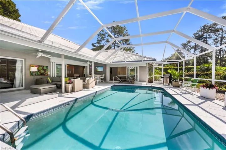 Swimming pool with outdoor lounge area, a patio, a sunroom, and glass enclosure